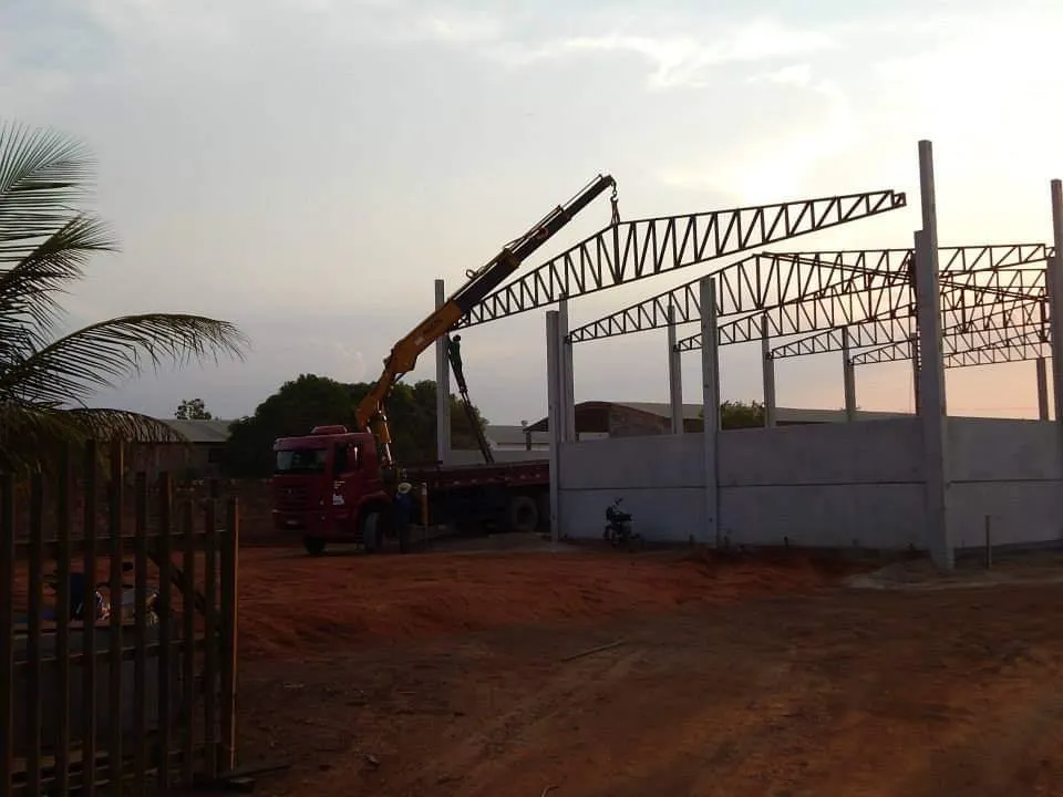 Estrutura metálica em fase de montagem para construção de barracão industrial, com pilares, vigas e tesouras sendo instaladas em campo