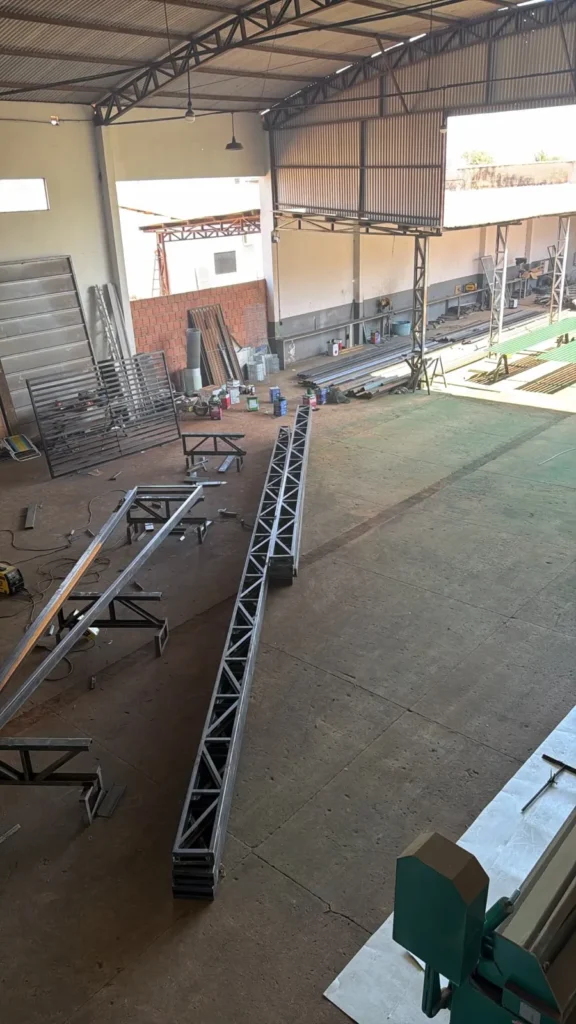 Tesouras e componentes de estrutura metálica no ambiente de fabricação da JS Metalúrgica